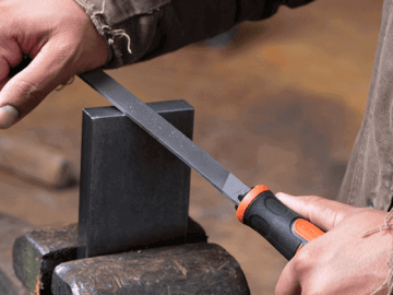 Man using a Nicholson american pattern file to file metal burrs